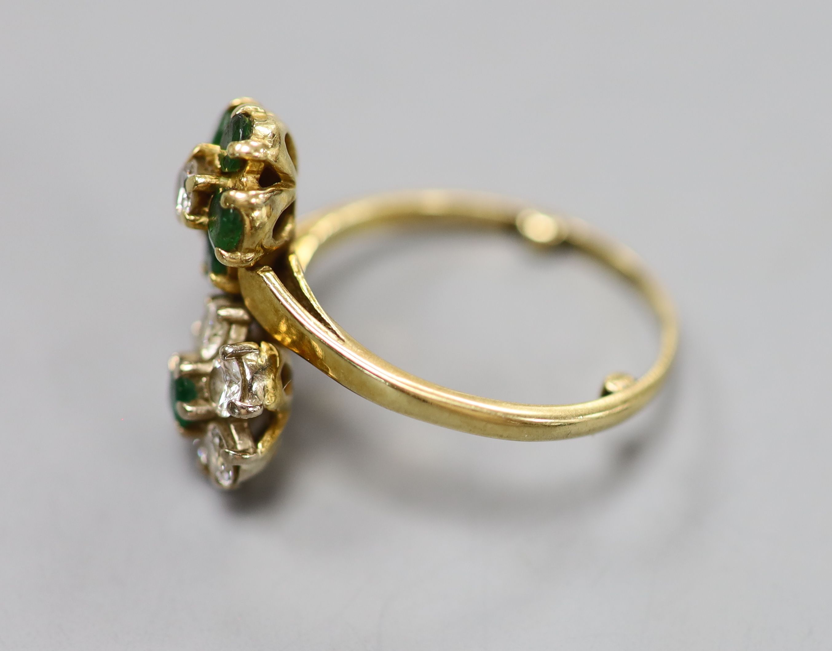 An 18ct, emerald and diamond double flowerhead cluster ring, size M, gross 4.5 grams.